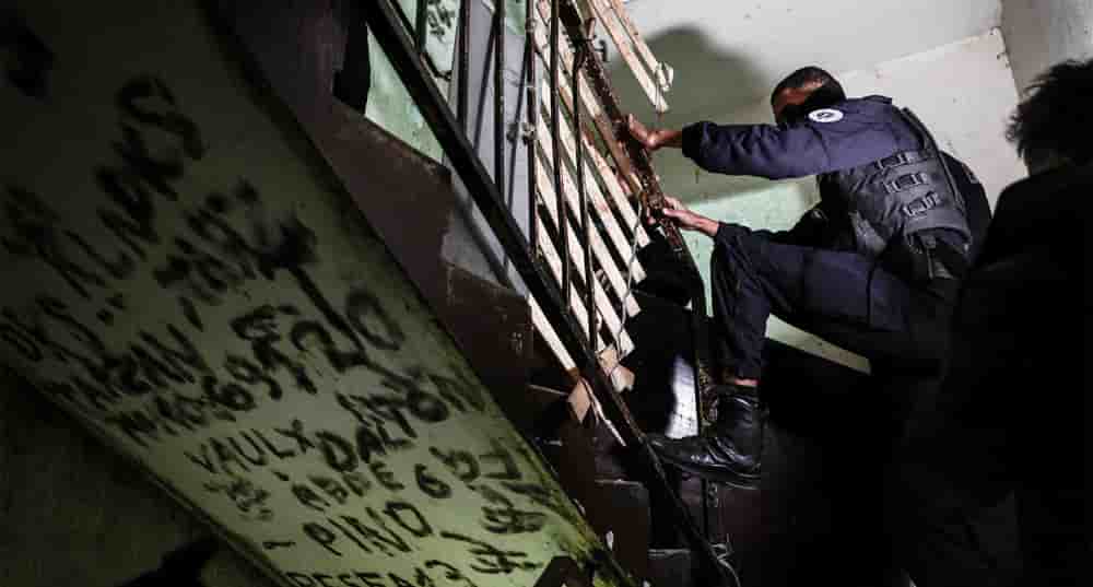 Des policiers de la brigade spécialisée BST14 de la Police nationale française entrent pour perquisitionner un immeuble du quartier de la Cité des Olivier à Marseille le 9 décembre 2025, lors d'une opération antidrogue.