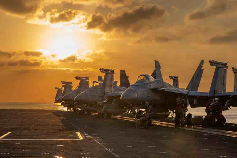 Des chasseurs de l’US Navy stationnés sur le pont d’envol de l’USS Abraham Lincoln, le 3 mars 2026, avant une sortie nocturne dans le cadre de l’opération Epic Fury. Cette esthétique du « soleil couchant », récurrente dans les images fournies par le...
