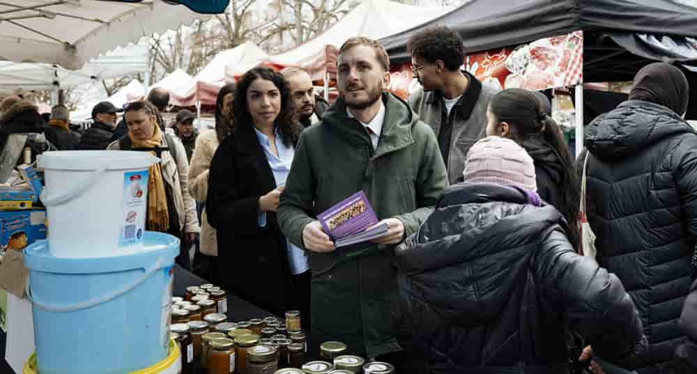 À Toulouse, François Piquemal (LFI) en pleine distribution de tracts sur le marché de Bagatelle pendant la campagne municipale.