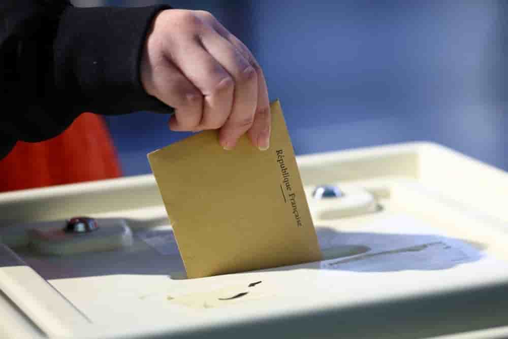 Une femme vote au premier tour des élections municipales françaises dans un bureau de vote à Marseille, en France, le 15 mars 2026.