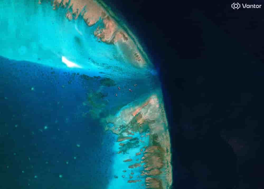 Une image satellite montrant des bateaux de pêche à l'entrée, bloquée par une barrière flottante, du récif de Scarborough, objet d'un litige, en mer de Chine méridionale, le 11 avril 2026.