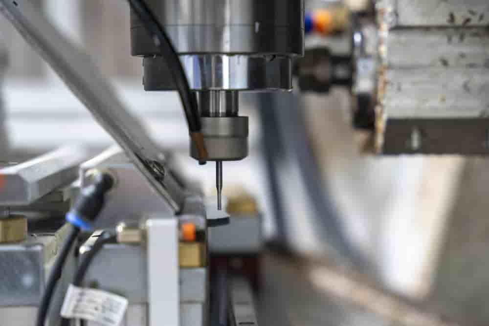 Machine outil numerique permettant la découpe des branches de lunettes à l'aide d'un tour industriel spécialisé au sein de l'usine de l'entreprise CMS lunettes et plastiques à Oyonnax, dans la « Plastics Vallée ».
