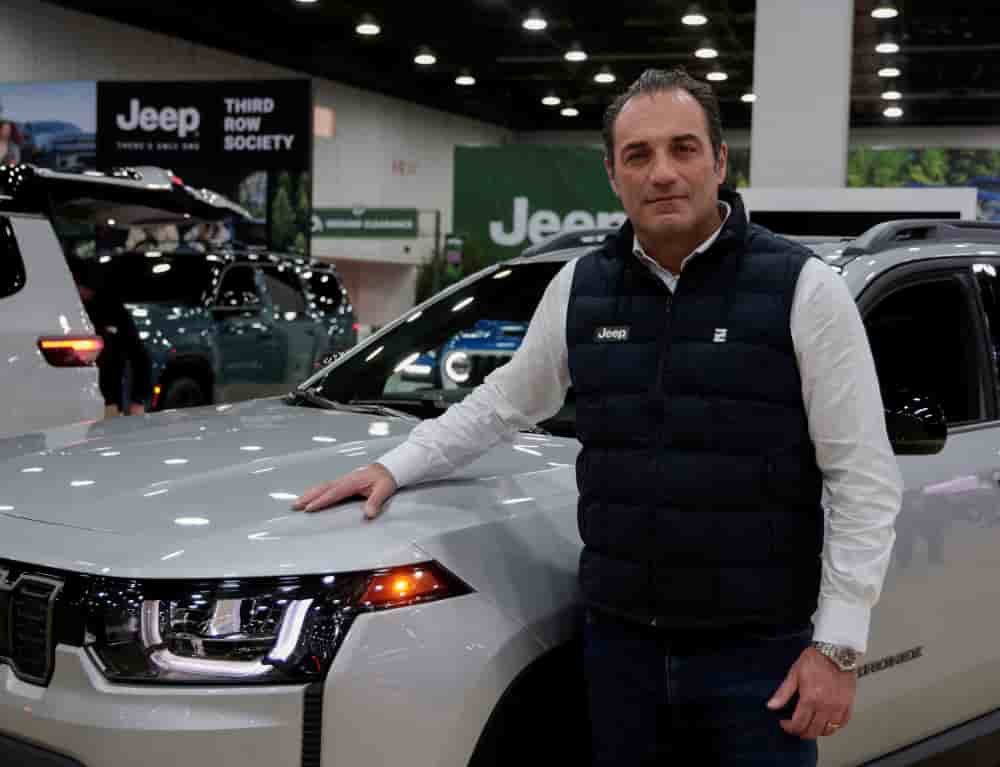 Le PDG de Stellantis, Antonio Filosa, pose à côté d'une Jeep Cherokee au Salon de l'auto de Detroit, le 14 janvier 2026.