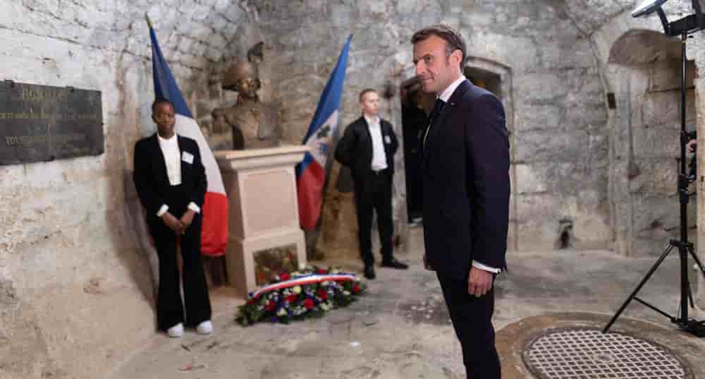 Le président Emmanuel Macron devant la statue de Toussaint Louverture, figure emblématique de la lutte pour l'indépendance d'Haïti, à La Cluze-et-Mijoux, près de Besançon (Doubs), le 27 avril 2023.