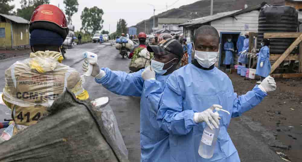 Des agents de santé déployés en réponse à l'épidémie d'Ebola vérifient la température et fournissent du désinfectant pour les mains aux motocyclistes qui passent par le point de contrôle de Kanyaruchinya, au nord de Goma.