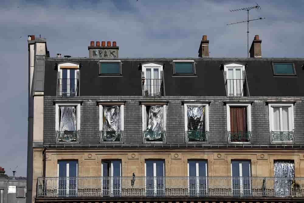 Les fenêtres d'un immeuble sont recouvertes de couvertures de survie pour se protéger du soleil alors que les températures grimpent à Paris.