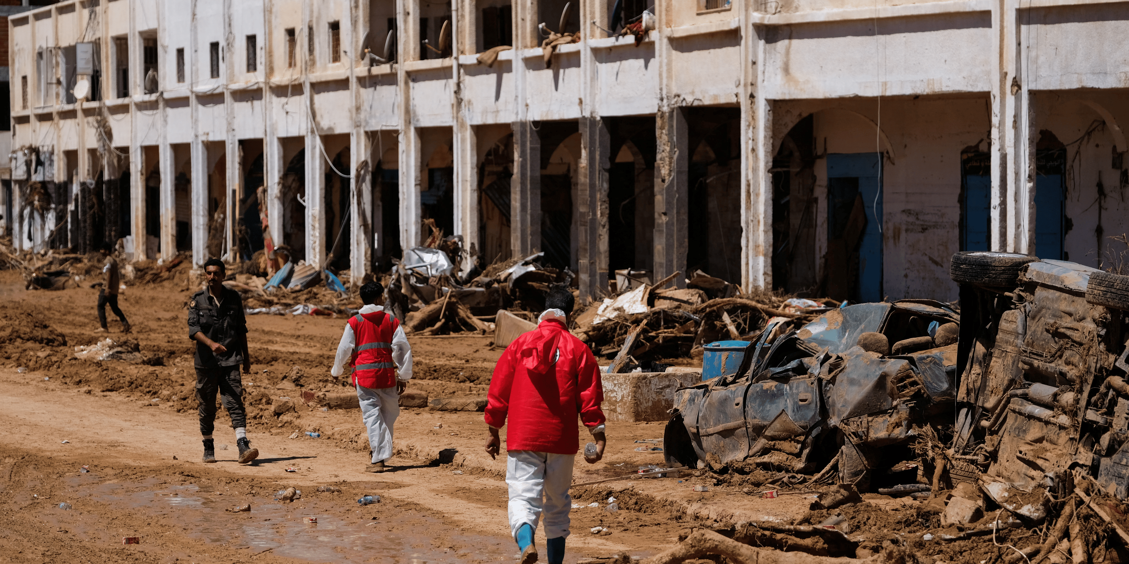 Des membres du croissant rouge marchent parmi des decombres a derna en libye