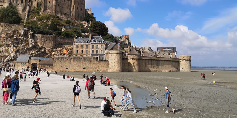 Pour accéder au Mont-Saint-Michel, les visiteurs empruntent un pont-passerelle sur pilotis qui redonne au site touristique son caractère maritime.
