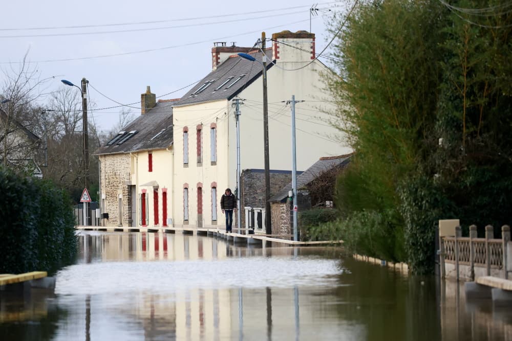 Un habitant marche sur un chemin de fortune, dans une zone inondée, à Redon, près de Rennes, le 30 janvier 2025.