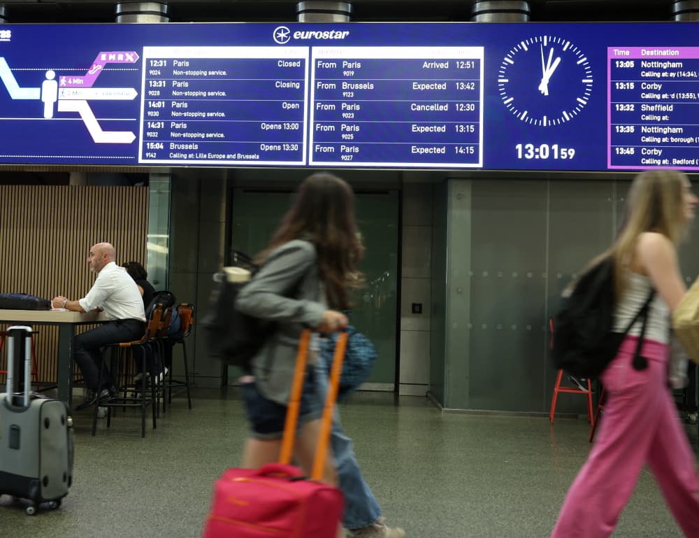 Des voyageurs passent devant un panneau indiquant l'annulation d'un train reliant Paris à Londres, à la gare internationale St. Pancras (photo d'archive ; juin 2025).