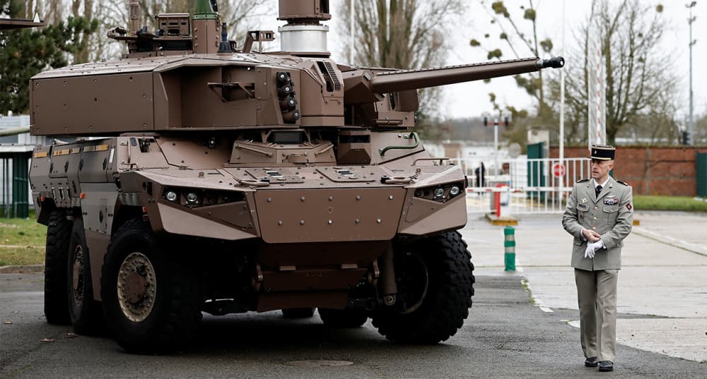 Un officier marche à côté d'un véhicule blindé de combat Jaguar.