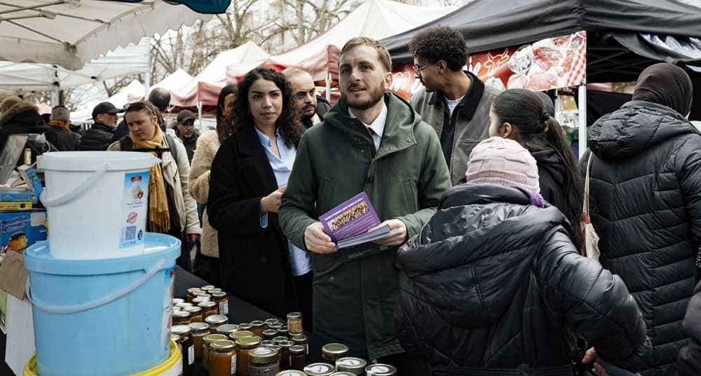 À Toulouse, François Piquemal (LFI) en pleine distribution de tracts sur le marché de Bagatelle pendant la campagne municipale.