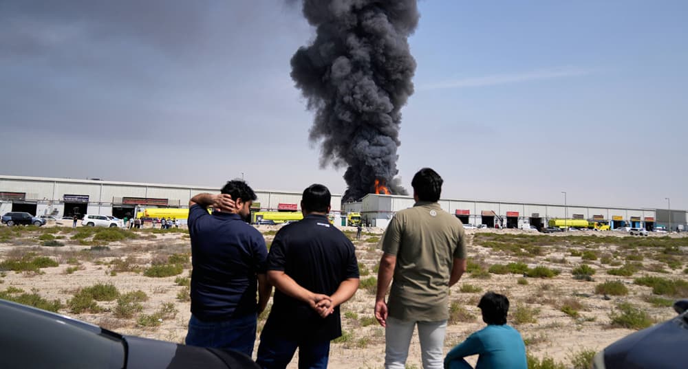 Aux Émirats arabes unis, des habitants regardent au loin les dégâts causés par une frappe iranienne.