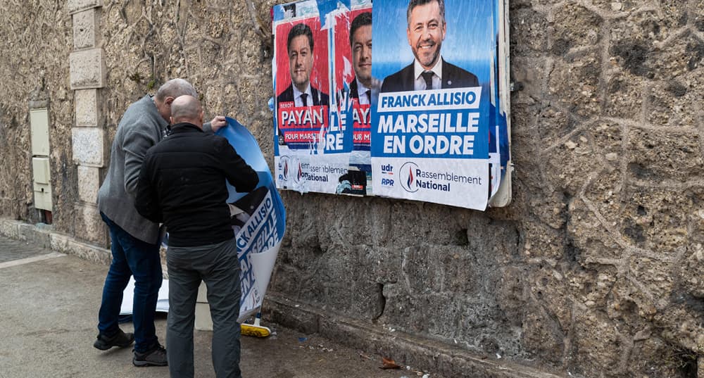 Des militants RN collent des affiches pour Franck Allisio, candidat à la mairie de Marseille.