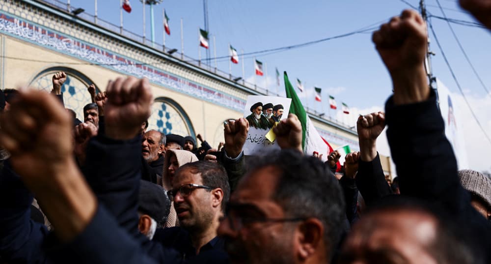 Des personnes assistent aux funérailles d'Ali Mohammad Naini, porte-parole du Corps des gardiens de la révolution islamique (CGRI) à Téhéran, le 21 mars 2026.