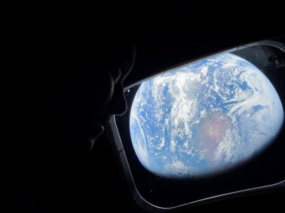 L'astronaute de la NASA et commandant d'Artemis II, Reid Wiseman, scrute par l'un des hublots principaux de la cabine du vaisseau spatial Orion, contemplant la Terre alors que l'équipage fait route vers la Lune, le 2 avril 2024.