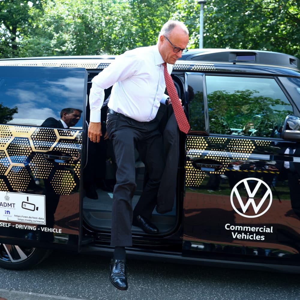 Le chancelier allemand descend d'un véhicule électrique autonome Volkswagen, à Hanovre, en Allemagne, le 22 juillet 2025.