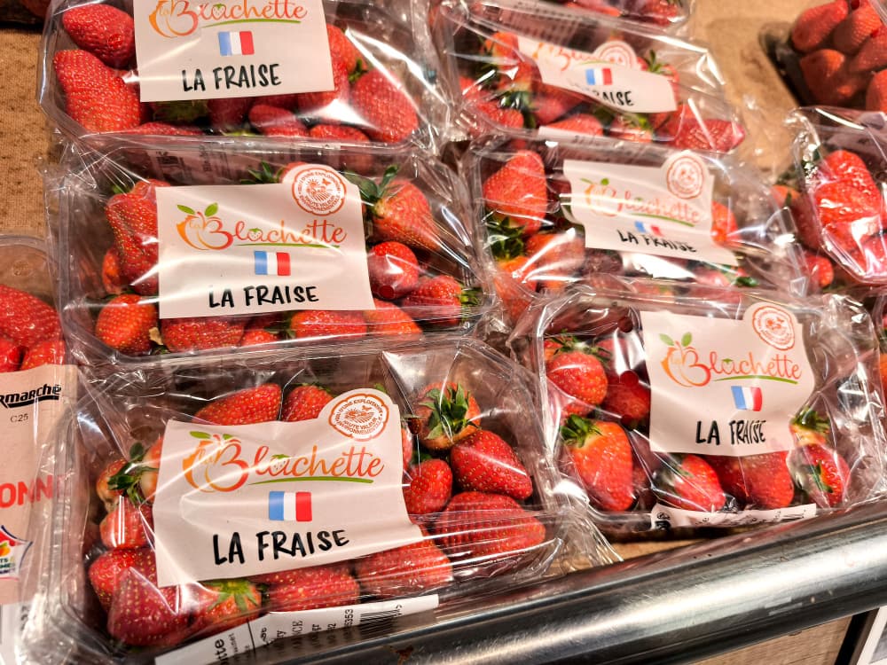 Des barquettes de fraises françaises emballées dans du plastique sur un étal de fruits dans un supermarché Intermarché à Valence, dans le département de la Drôme.