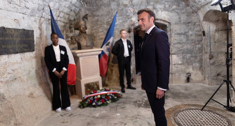 Le président Emmanuel Macron devant la statue de Toussaint Louverture, figure emblématique de la lutte pour l'indépendance d'Haïti, à La Cluze-et-Mijoux, près de Besançon (Doubs), le 27 avril 2023.