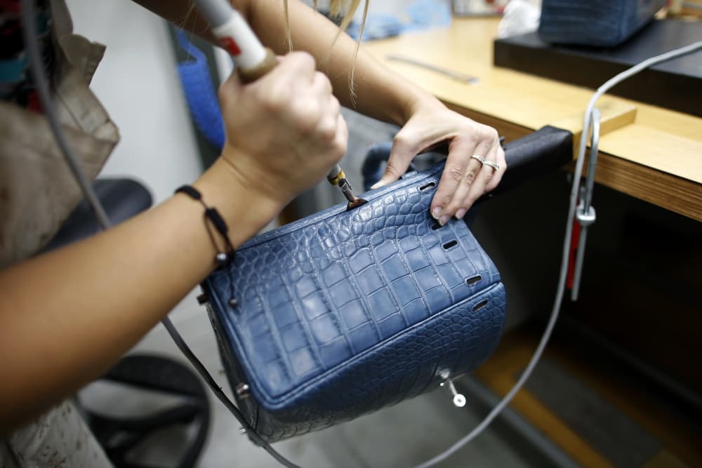 Une artisane travaille sur un sac Kelly à l'usine d'articles de luxe Hermès à Seloncourt (Doubs), le 4 octobre 2013. (Image d'illustration