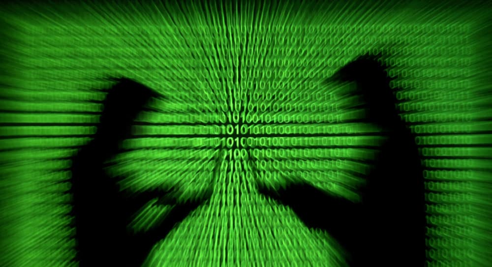 FILE PHOTO: Silhouettes of laptop users are seen next to a screen projection of binary code are seen in this picture illustration created on March 28, 2018. REUTERS/Dado Ruvic/Illustration/File Photo - FILE PHOTO: Silhouettes of laptop users are seen...