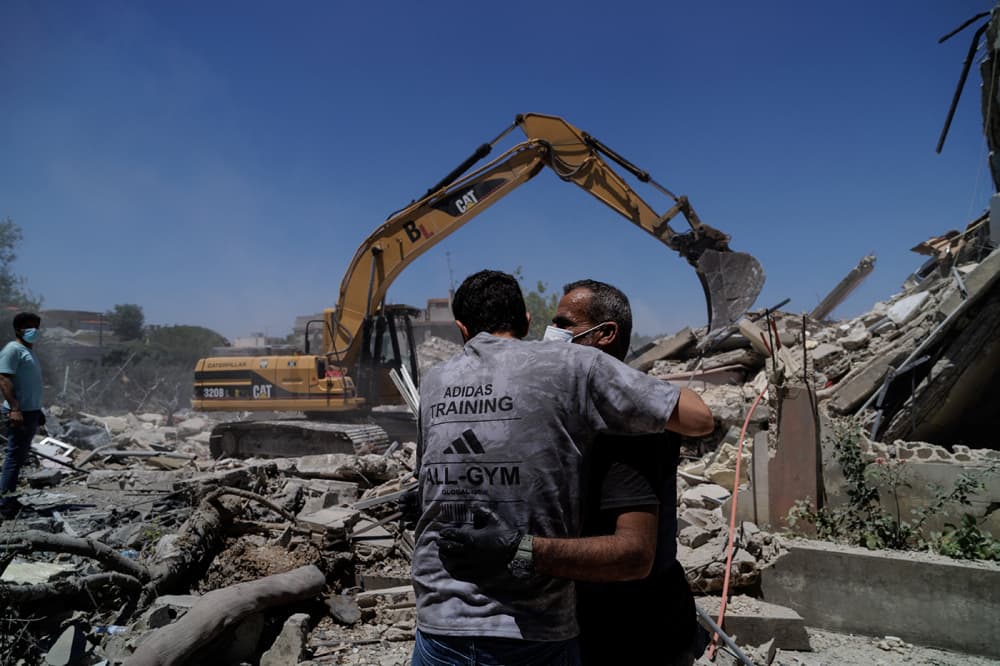 Des secouristes s'étreignent alors qu'ils interviennent sur le site d'une frappe aérienne israélienne à Barish, dans le district de Tyr, au Liban, le 20 juin 2026.