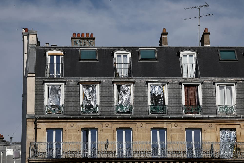Les fenêtres d'un immeuble sont recouvertes de couvertures de survie pour se protéger du soleil alors que les températures grimpent à Paris.