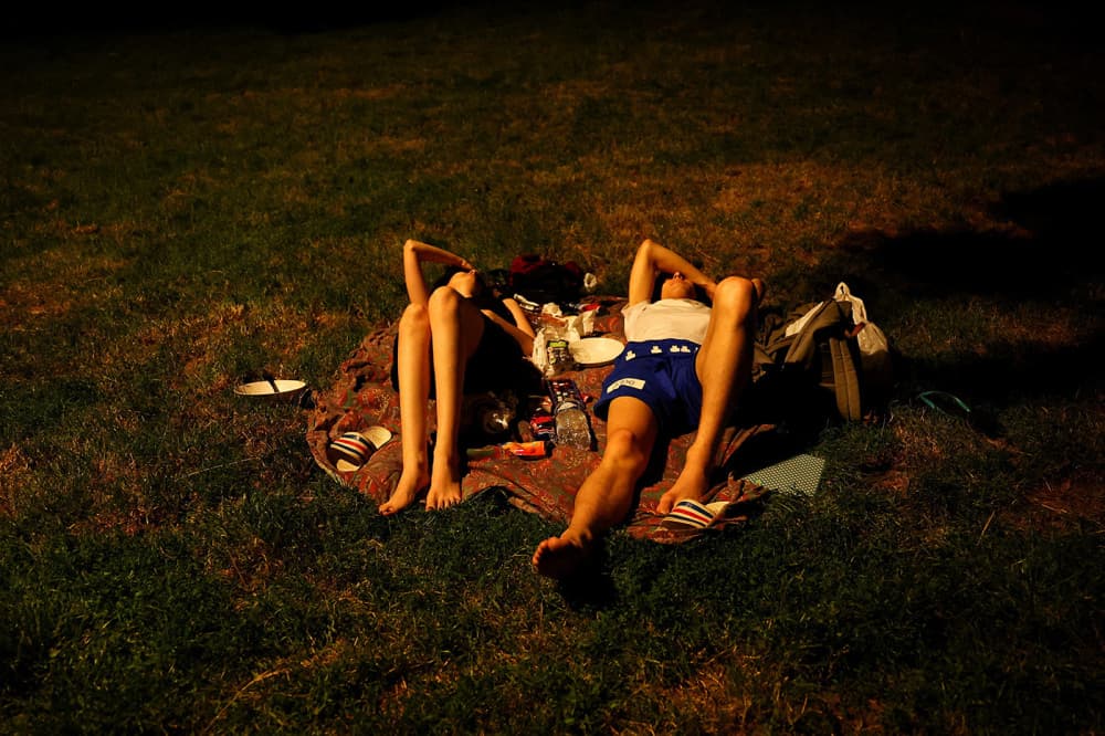 Des personnes se reposent sur les pelouses du parc des Buttes-Chaumont, à Paris, alors que les températures grimpent pendant une vague de chaleur qui touche une grande partie de la France, le 26 juin 2026.