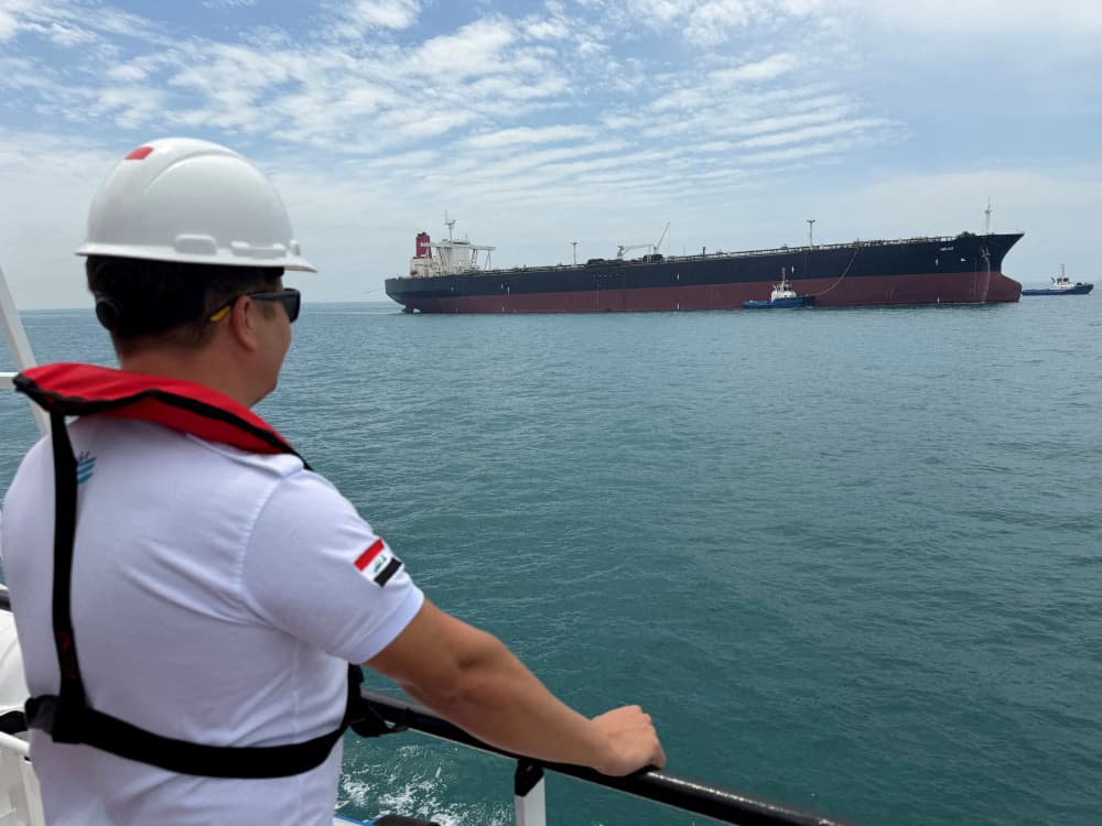 FILE PHOTO: A sailor observes the oil tanker HELGA, which is moored at one of Iraq's southern offshore oil terminals near Basra, as it prepares to load crude oil, becoming the second vessel to arrive since the closure of the Strait of Hormuz, April 24,...