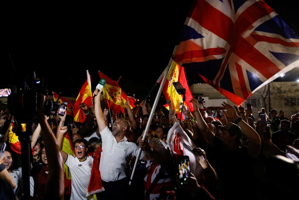 Des personnes agitent des drapeaux espagnols et un drapeau britannique pour célébrer la mise en œuvre de l'accord sur Gibraltar, vers minuit le 15 juillet 2026.