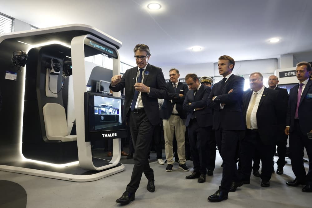 Emmanuel Macron écoute Patrice Caine, président-directeur général du groupe Thales, lors de sa visite au pavillon de l'entreprise au Salon international de l'aéronautique et de l'espace de Paris, à l'aéroport de Paris-Le Bourget, en juin 2025.