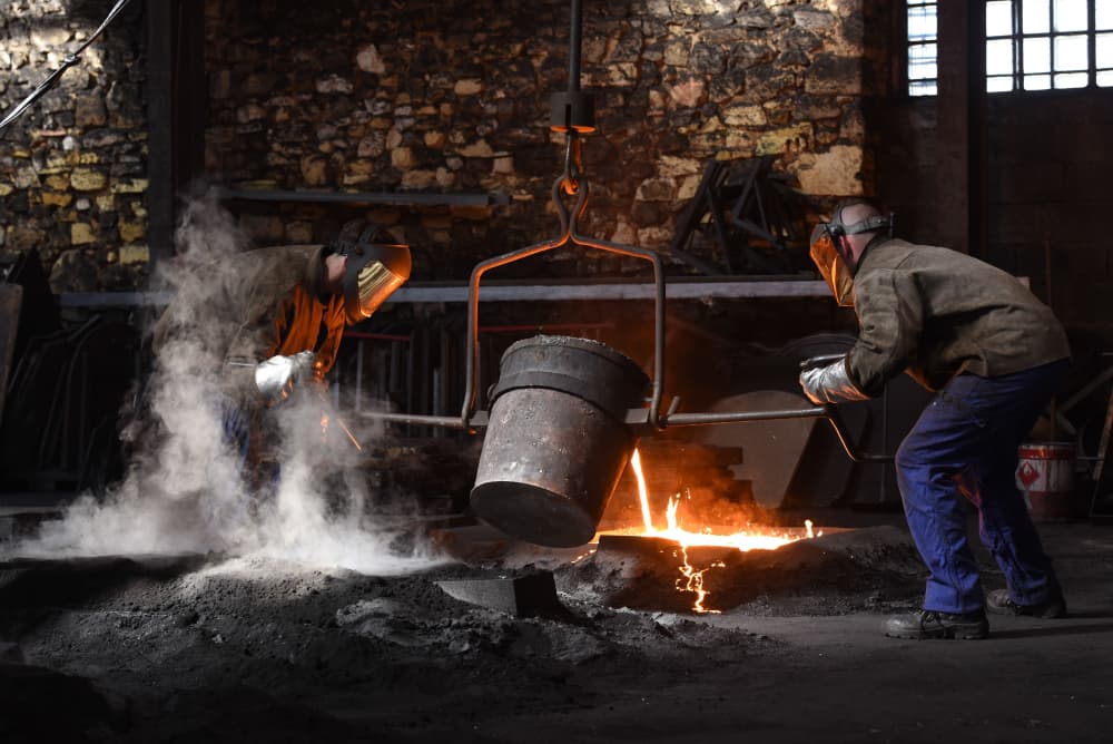Le travail de la fonte dans une fonderie de Dordogne. Ici, des ouvriers coulent des plaques de cheminée avec de la fonte en fusion. (Image d'illustration)
