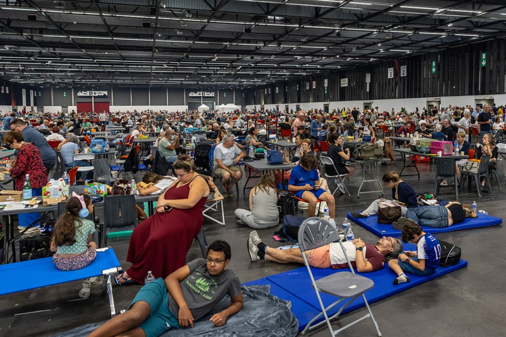 Des habitants et des touristes évacués en raison des incendies en Gironde dorment sur des lits de camp au parc des expositions de Bordeaux, transformé en centre d’accueil temporaire, le 25 juillet 2026.